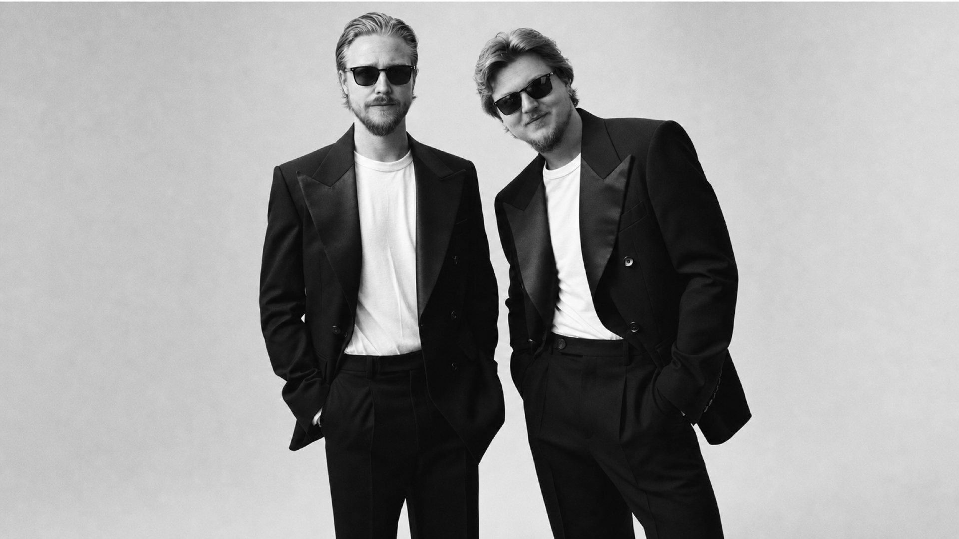 Black and white portrait of the two ARSORA co-founders in black suits and sunglasses