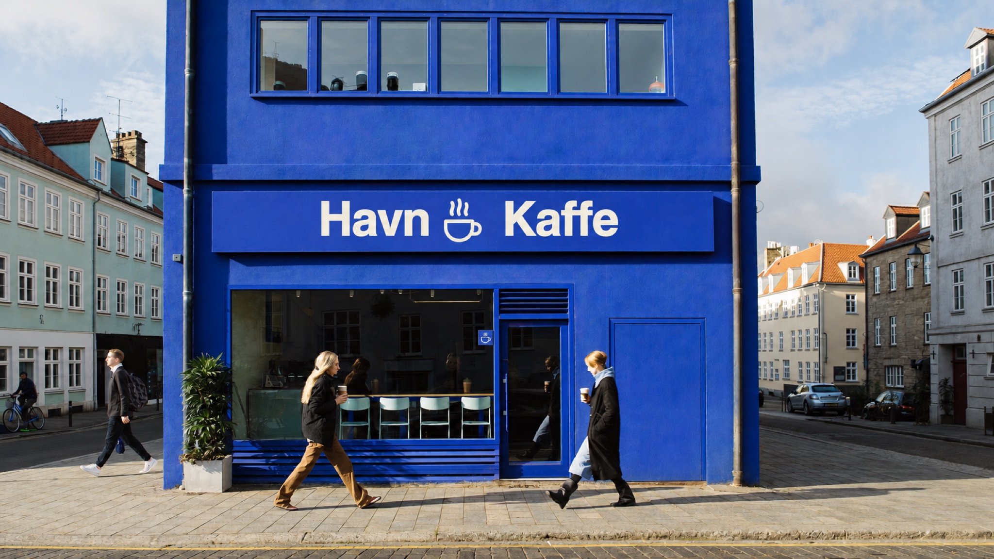 Кобальтовая угловая лавка Havn Kaffe в утреннем солнце