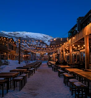 A lantern-lit winter patio with wooden tables