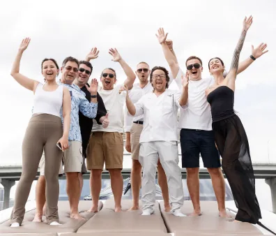 Entrepreneurs cheering with raised arms on a yacht deck