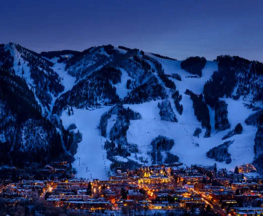 Aspen ski slopes above the lights of the town at dusk