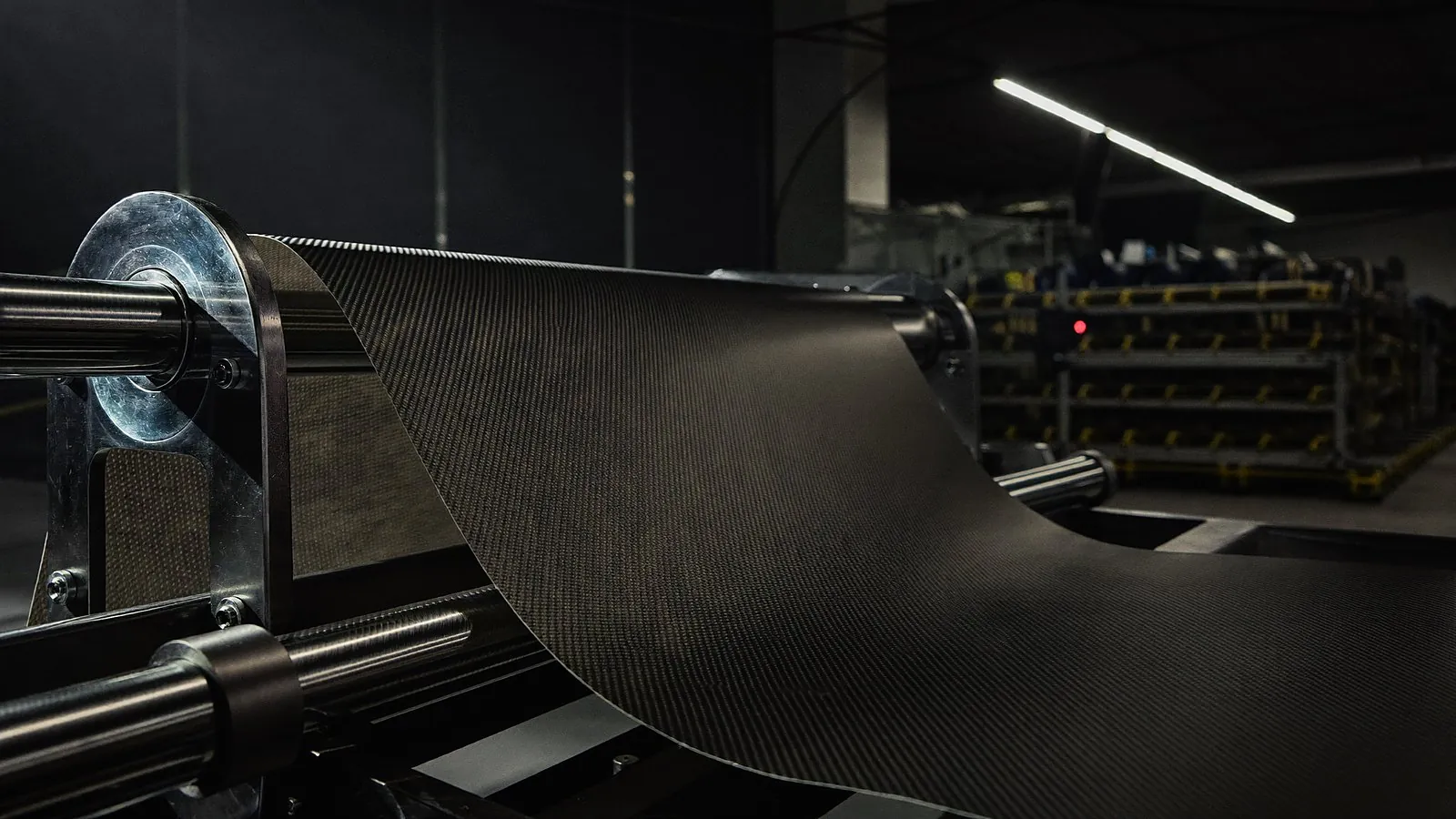 Carbon fiber sheet flowing over rollers on a composite production line